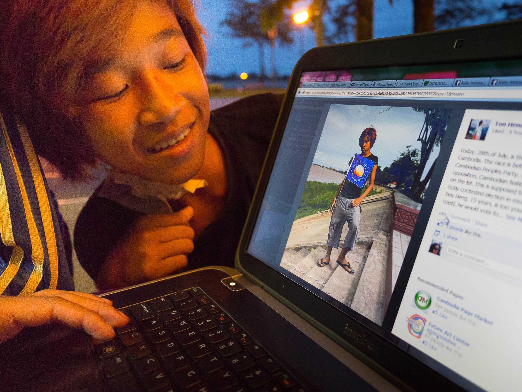 Street boy watches his photo on Facebook, global Street Child in Phnom Penh
